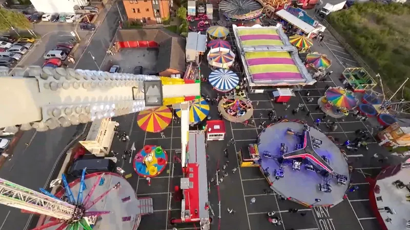 Aerial view of a packed Denzil Danter funfair with rides and crowds