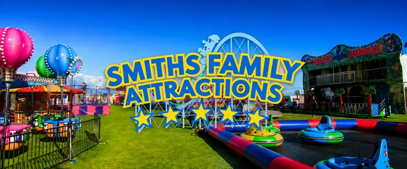 Smiths Family Attractions funfair with dodgems, balloons and rides under a blue sky